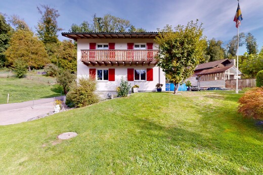 view of property featuring a yard, a balcony, and stucco siding