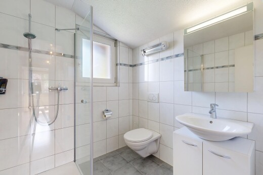 full bathroom featuring a shower stall, tile walls, vanity, and light tile patterned flooring
