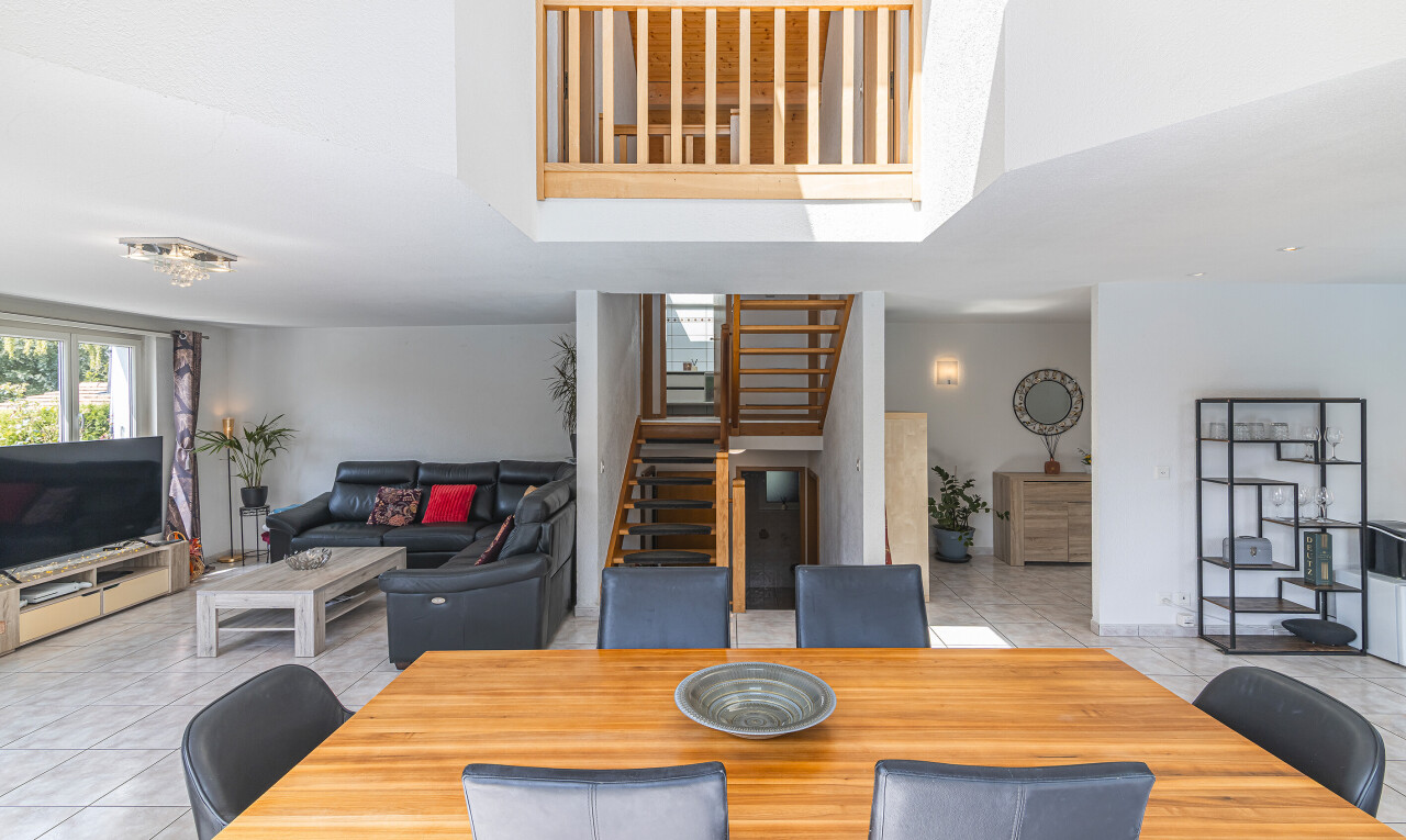 living room with light tile patterned flooring, stairway, and a high ceiling