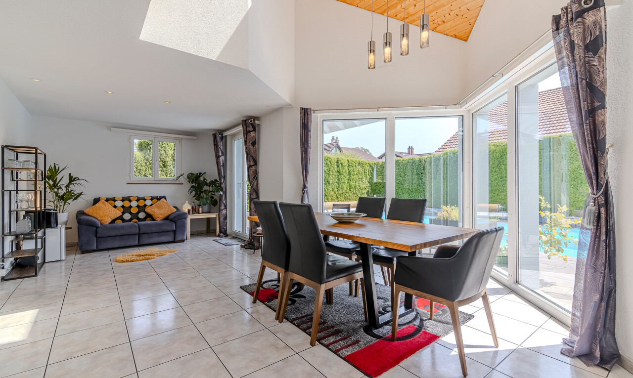 living room featuring high vaulted ceiling, light tile patterned floors, a wood ceiling with exposed beams, and a skylight