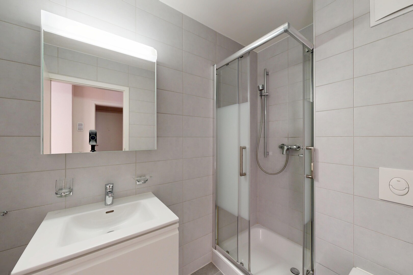 bathroom featuring a stall shower, tile walls, and vanity