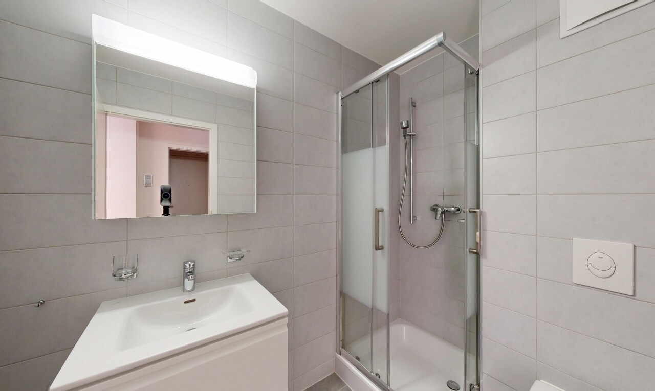 bathroom featuring a stall shower, tile walls, and vanity