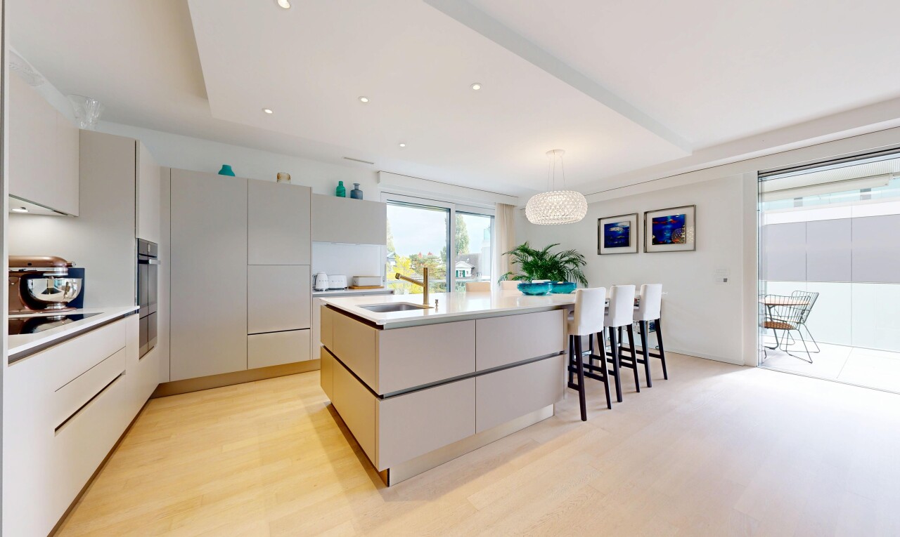 cuisine avec armoires à panneau plat, îlot de cuisine, éclairage suspendu, lumière naturelle, et natural light