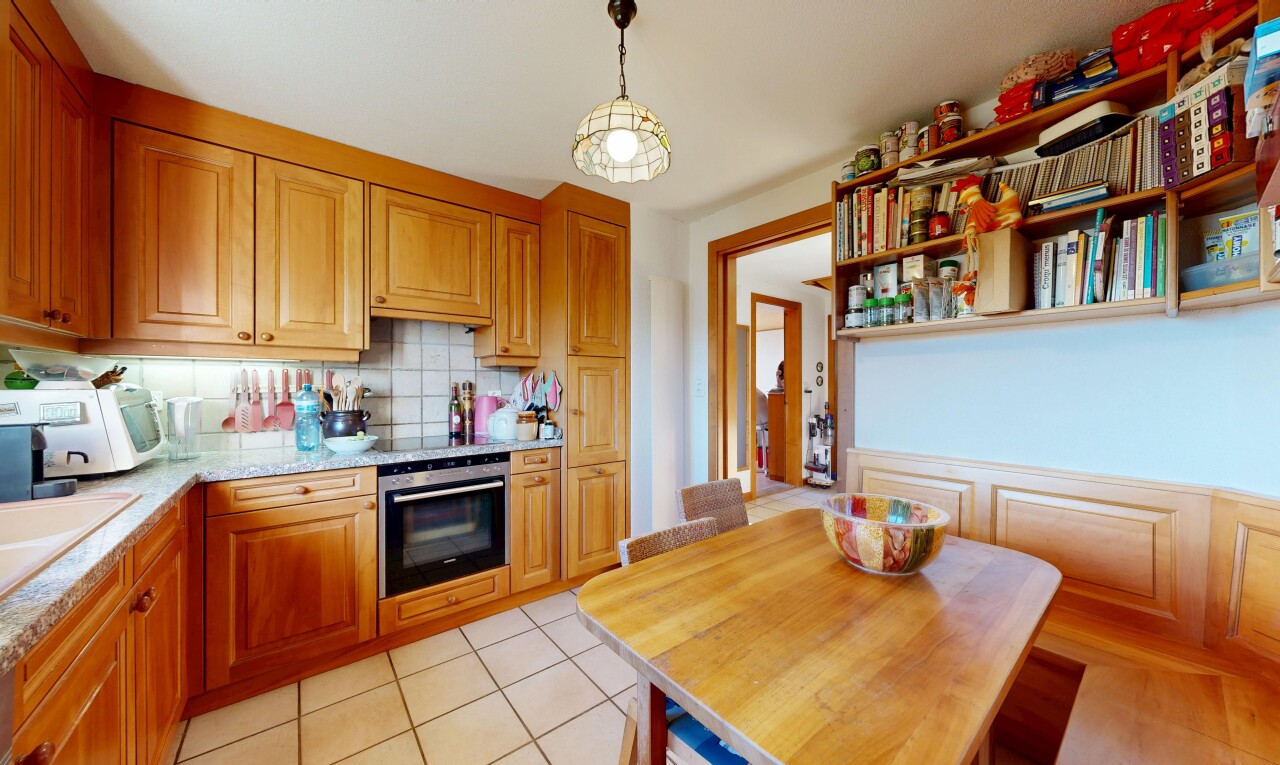 cuisine avec armoires élevées, four, cloison sèche, drywall, et inside property