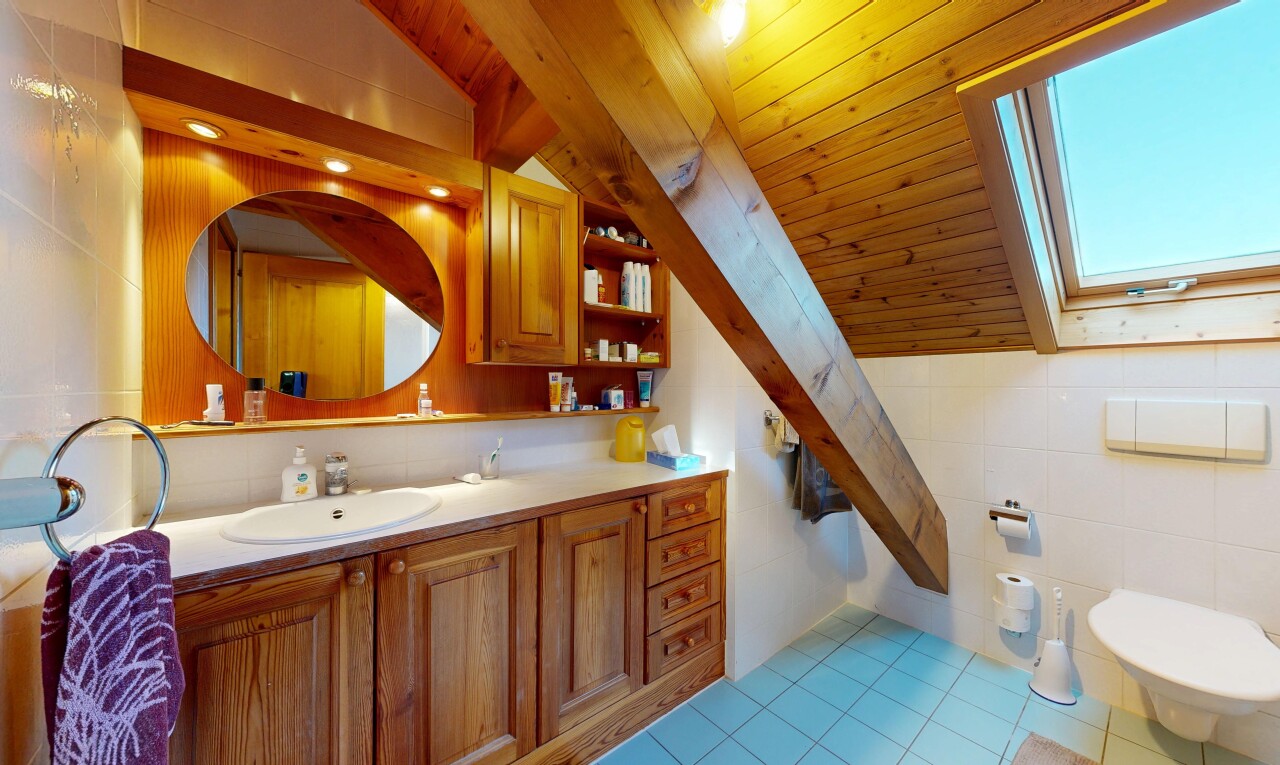 salle de bains avec lavabo (ou coiffeuse selon le contexte), mur en carrelage, tile wall, plafond voûté, et vaulted ceiling