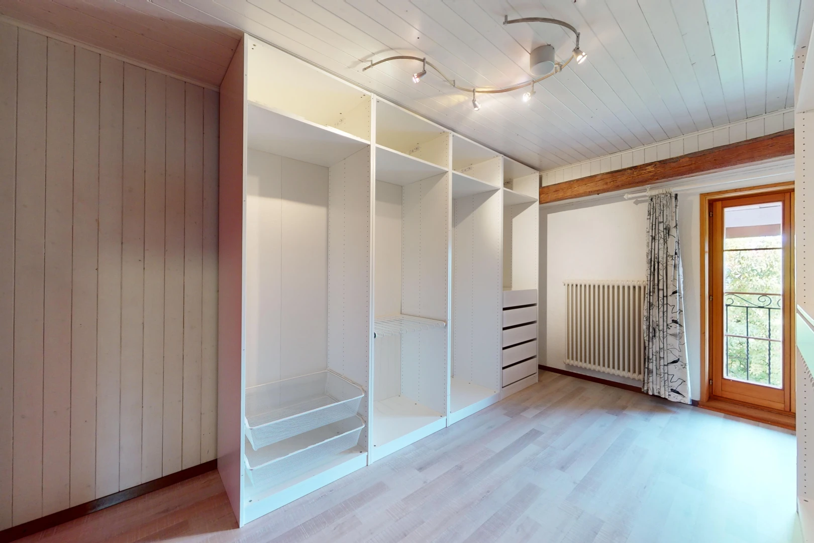 spacious closet with hardwood / wood-style flooring and radiator heating unit