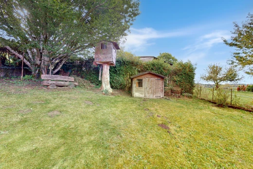 garden featuring a storage unit and a lawn