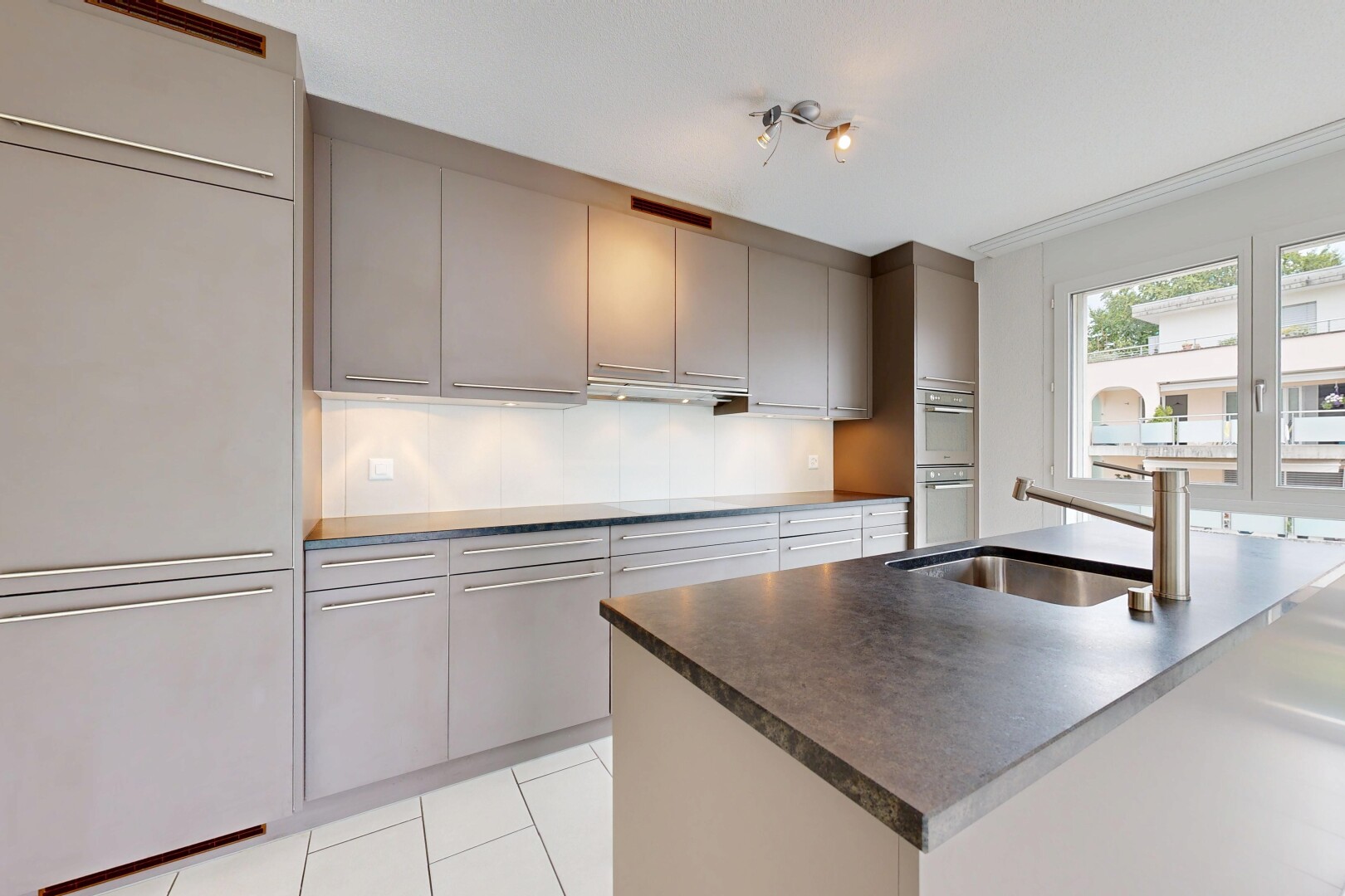 küche mit graue schränke, gray cabinets, light floor, arbeitsplatten, und dark countertops