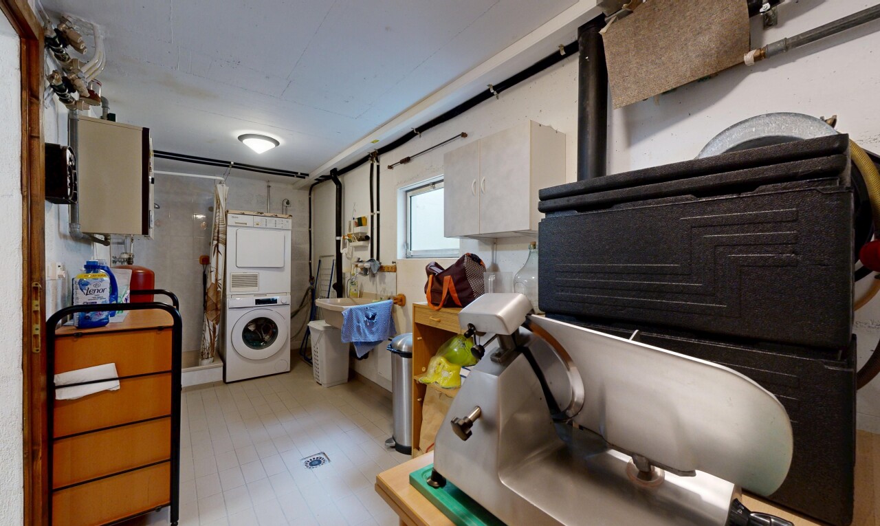 laundry area with stacked washer and dryer and light wood-style floors