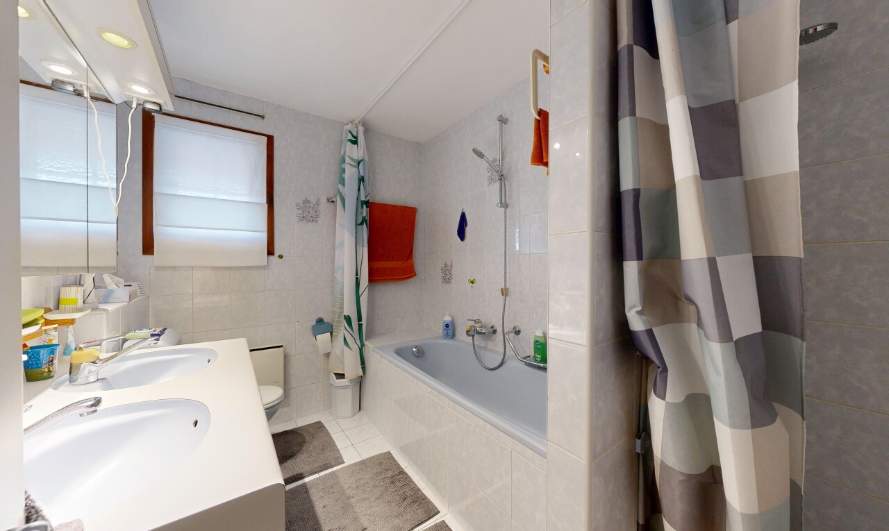full bath featuring tiled shower / bath, tile walls, double vanity, and light tile patterned floors