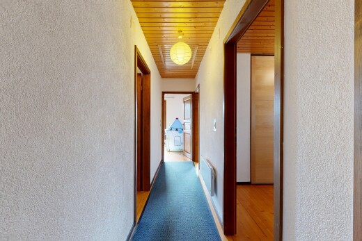couloir avec mur texturé, textured wall, inside property, plafond en bois, et wood ceiling
