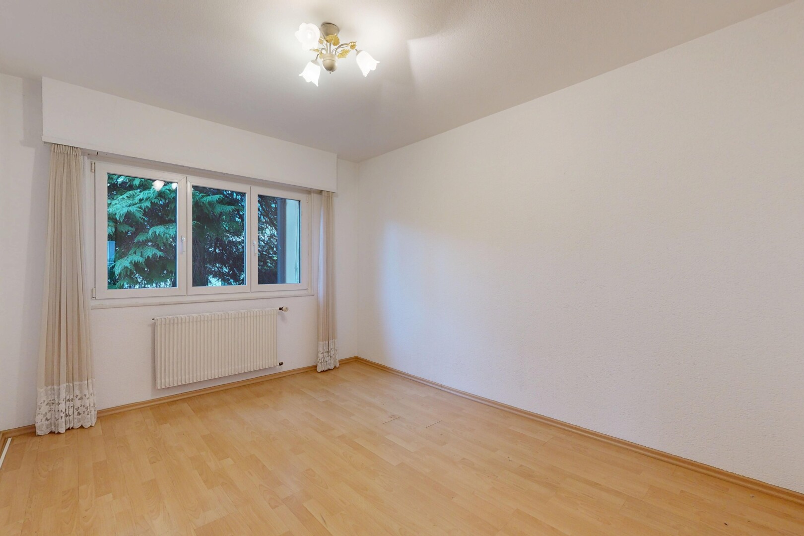 pièce vide avec radiateur, sol en finition bois, wood finish floor, cloison sèche, et drywall