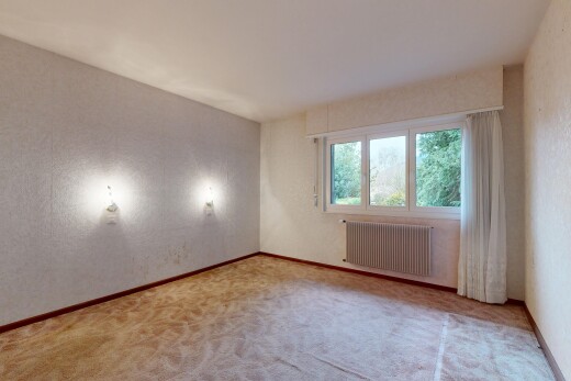 spare room with radiator heating unit and light colored carpet