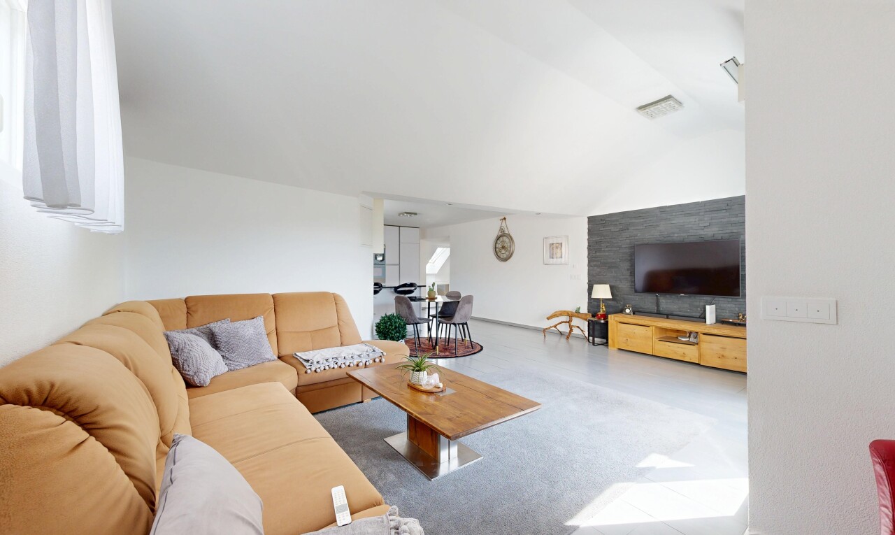 salon avec inside property, cloison sèche, drywall, télévision, et plafond voûté
