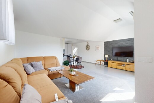 salon avec inside property, cloison sèche, drywall, télévision, et plafond voûté