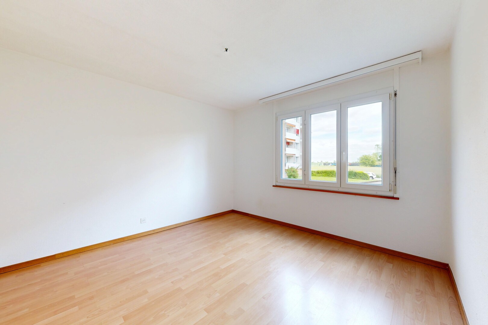 pièce vide avec cloison sèche, drywall, sol en finition bois, wood finish floor, et lumière naturelle