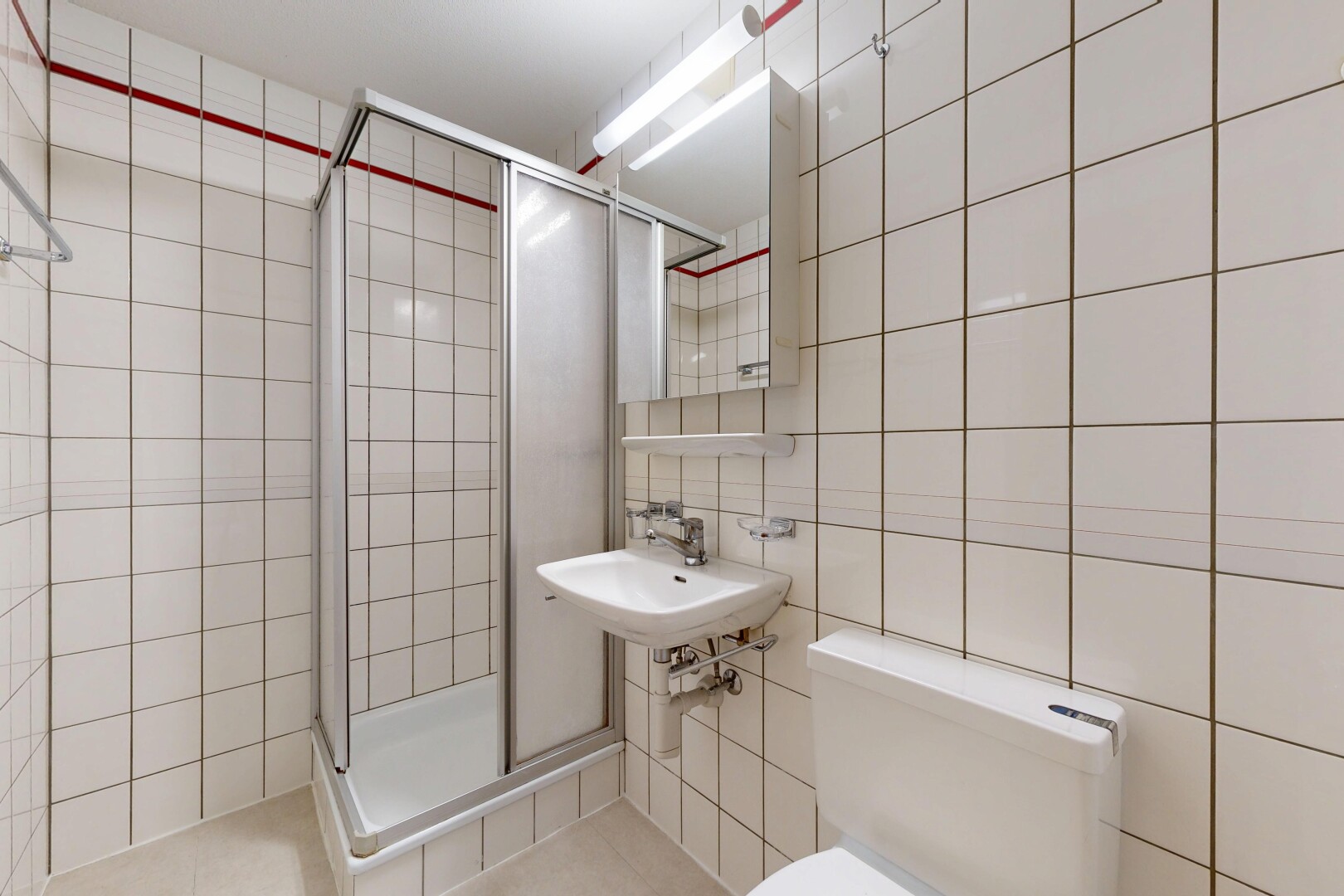 salle de bains avec mur en carrelage, tile wall, miroir, douche, et salle de bain complète