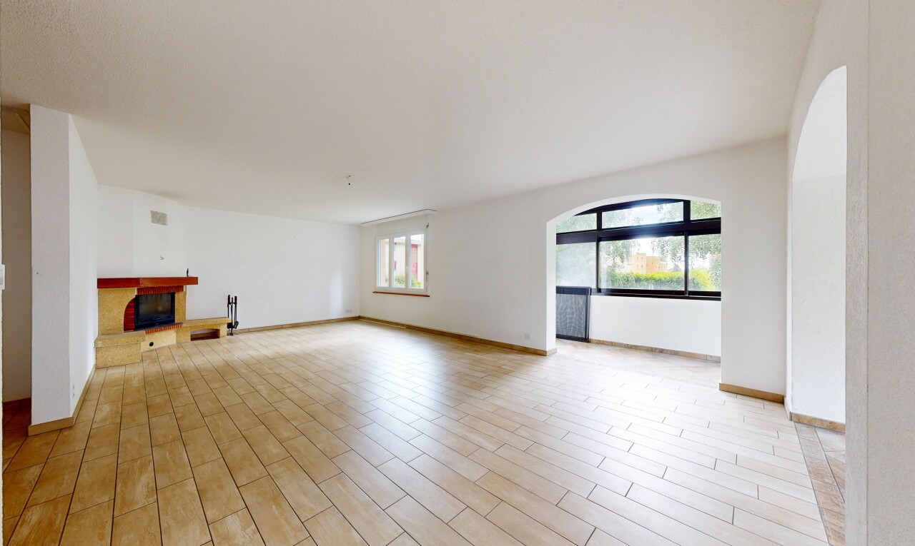 pièce vide avec inside property, cheminée, sol en finition bois, wood finish floor, et lumière naturelle