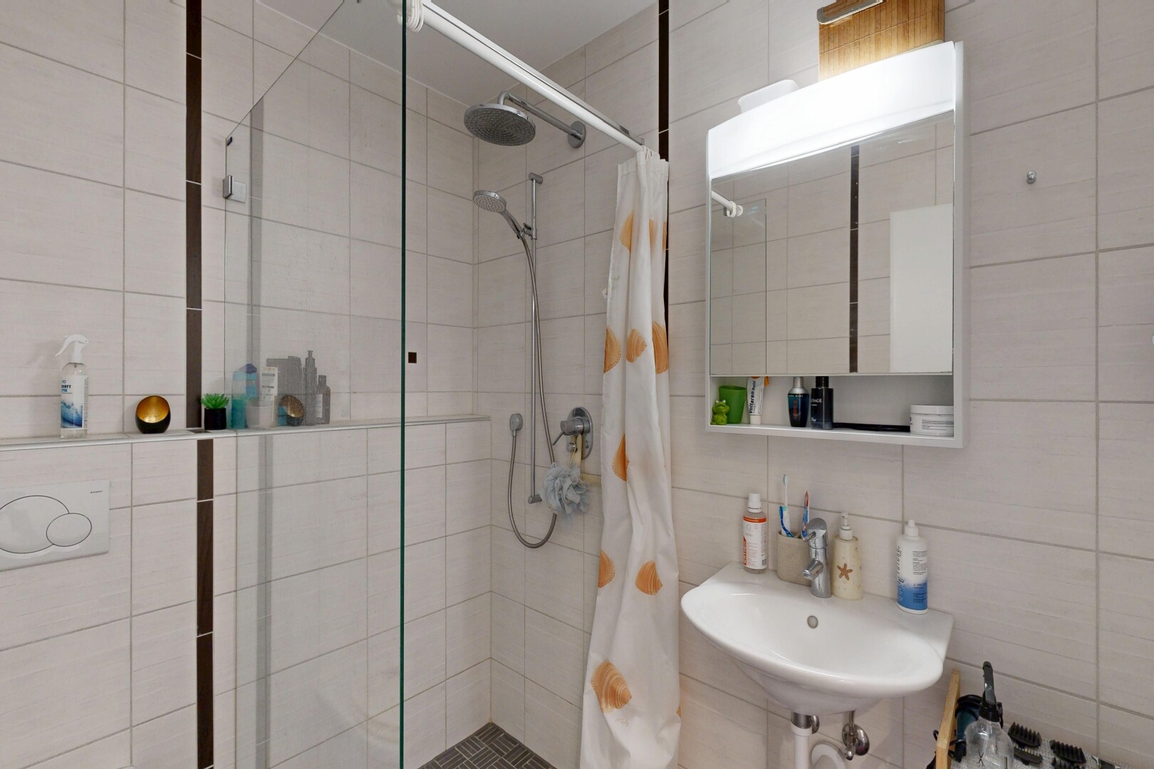 salle de bains avec miroir, salle de bain complète, douche, inside property, et mur en carrelage