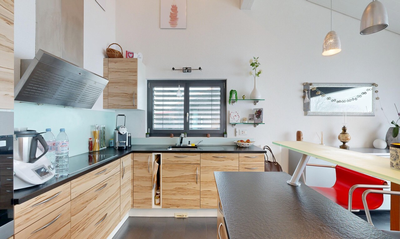 cuisine avec plans de travail, dark countertops, armoires marron clair, light brown cabinets, et hotte