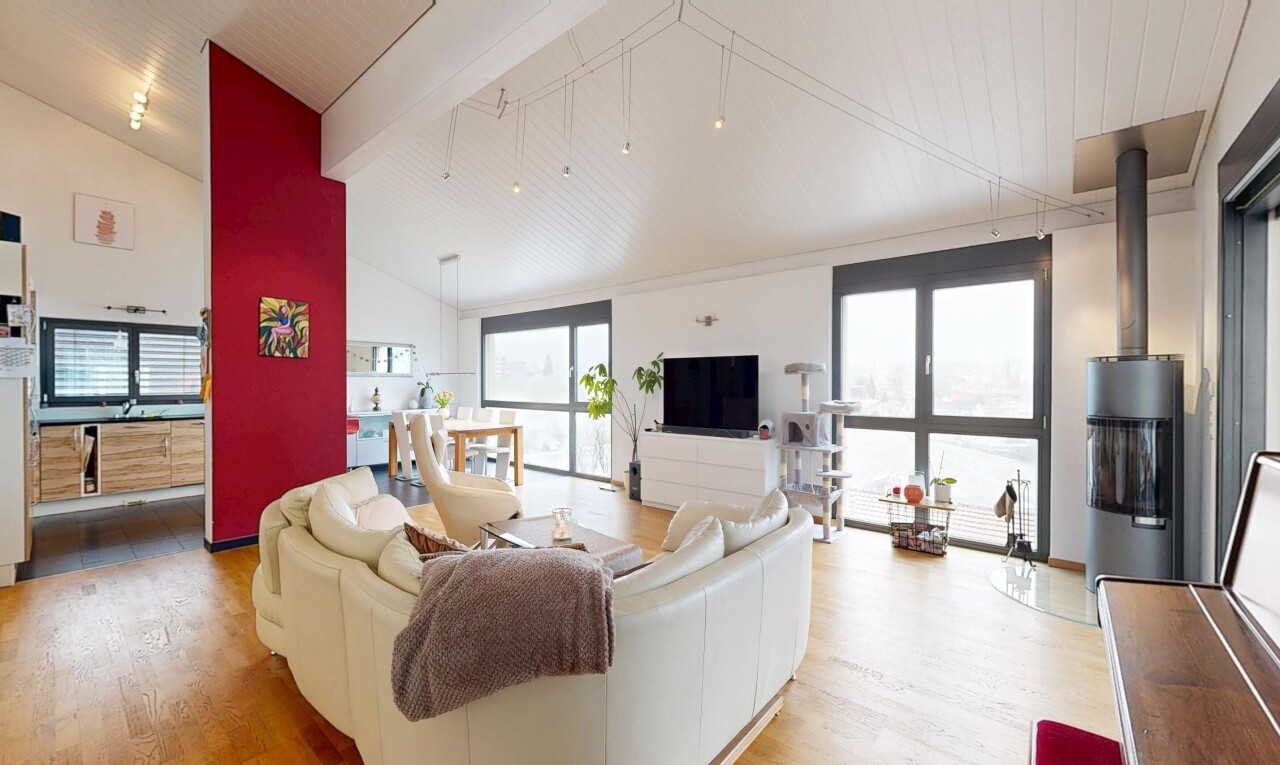 salon avec inside property, télévision, sol en finition bois, wood finish floor, et plafond voûté