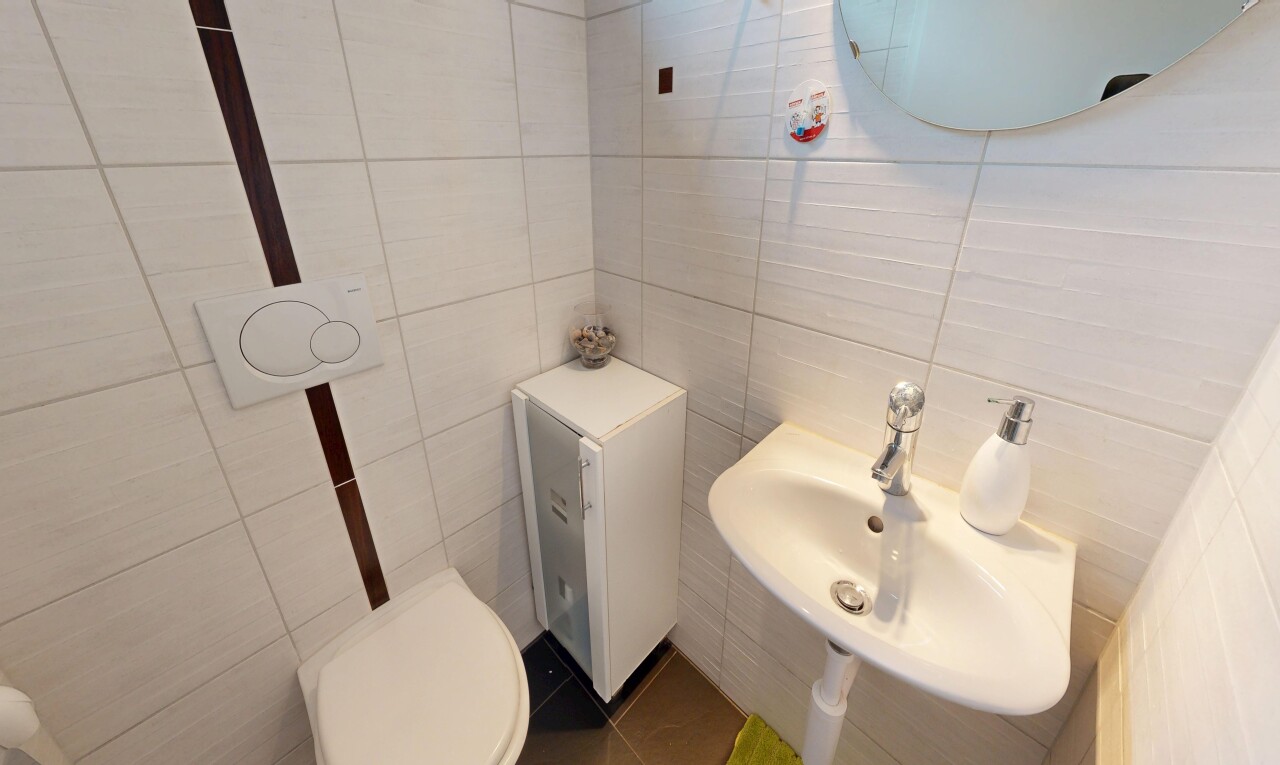 salle de bains avec mur en carrelage, tile wall, miroir, inside property, et toilette