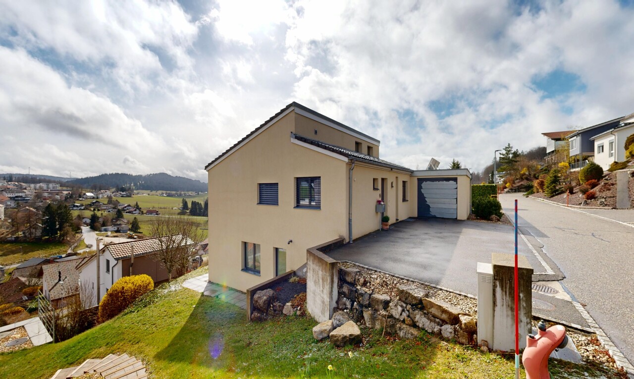 façade avec property visible, bardage en stuc, day time, et garage attaché