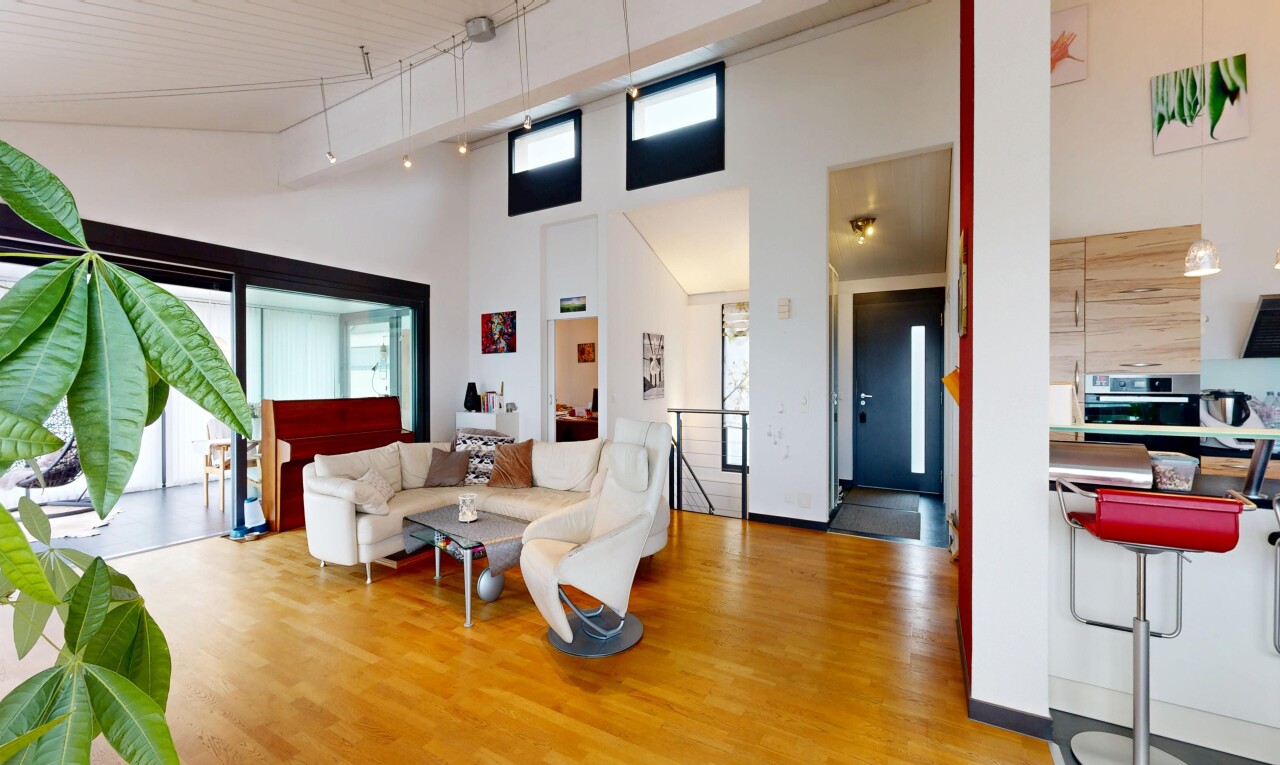salon avec sol en finition bois, wood finish floor, inside property, lumière naturelle, et natural light