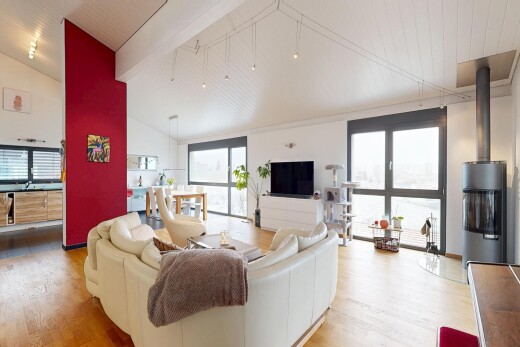 salon avec inside property, télévision, sol en finition bois, wood finish floor, et plafond voûté
