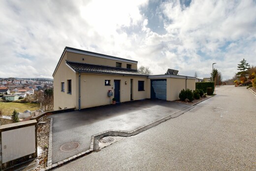 façade avec bardage en stuc, property visible, garage attaché, allée, et day time