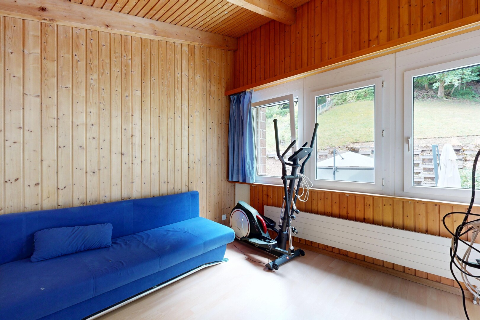 exercise room with wood walls, a wooden ceiling with exposed beams, and wood finished floors