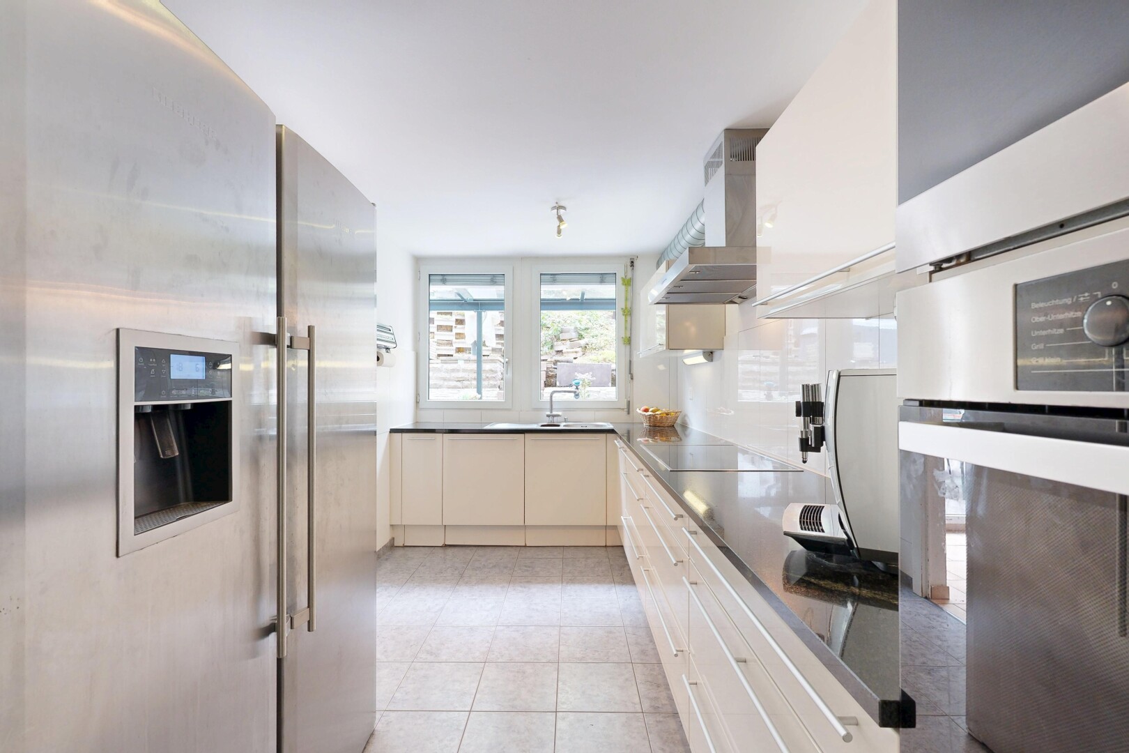 kitchen with stainless steel appliances, dark countertops, and light tile patterned flooring