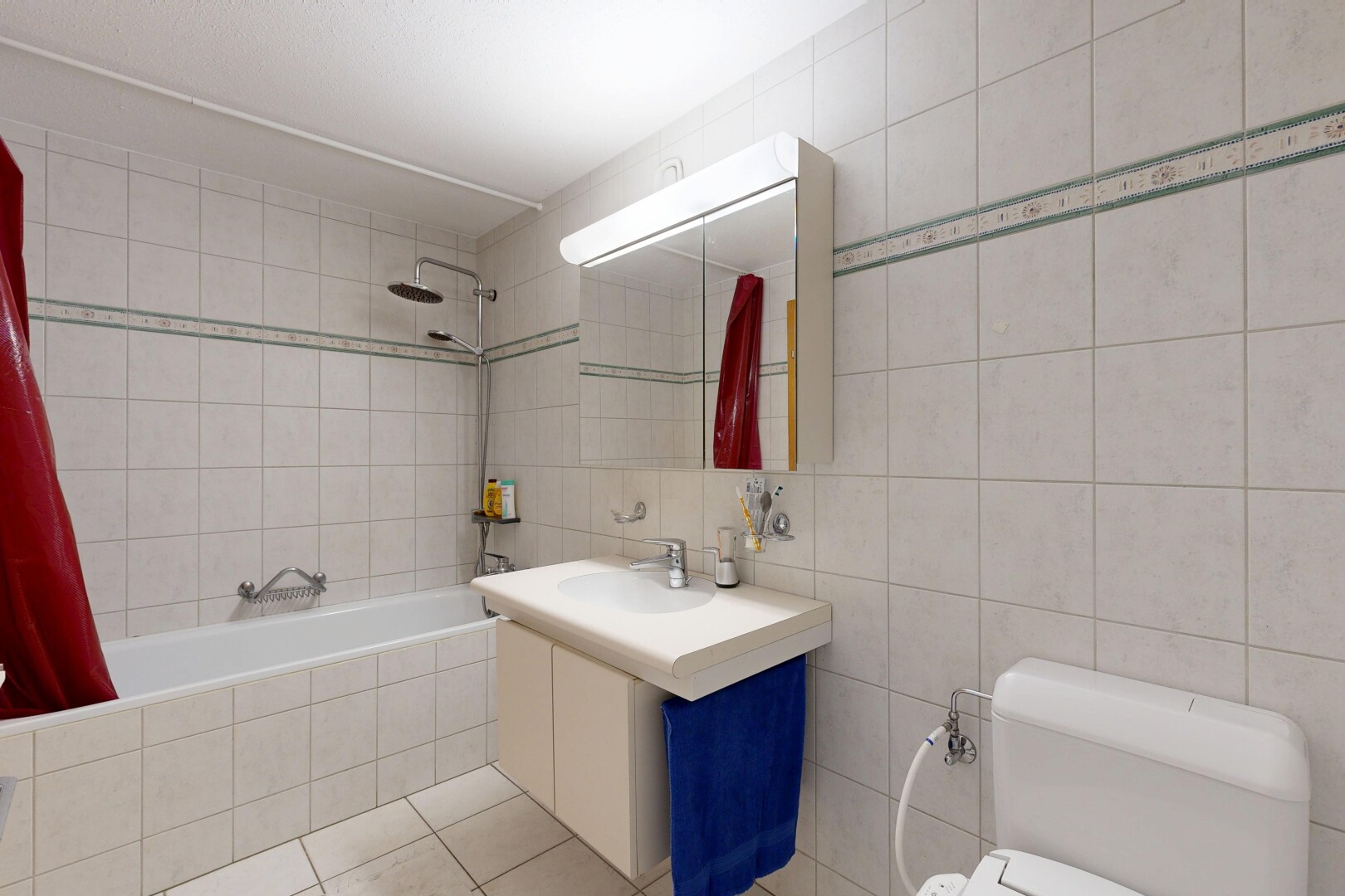 full bathroom with tile walls, tiled shower / bath combo, vanity, and light tile patterned flooring