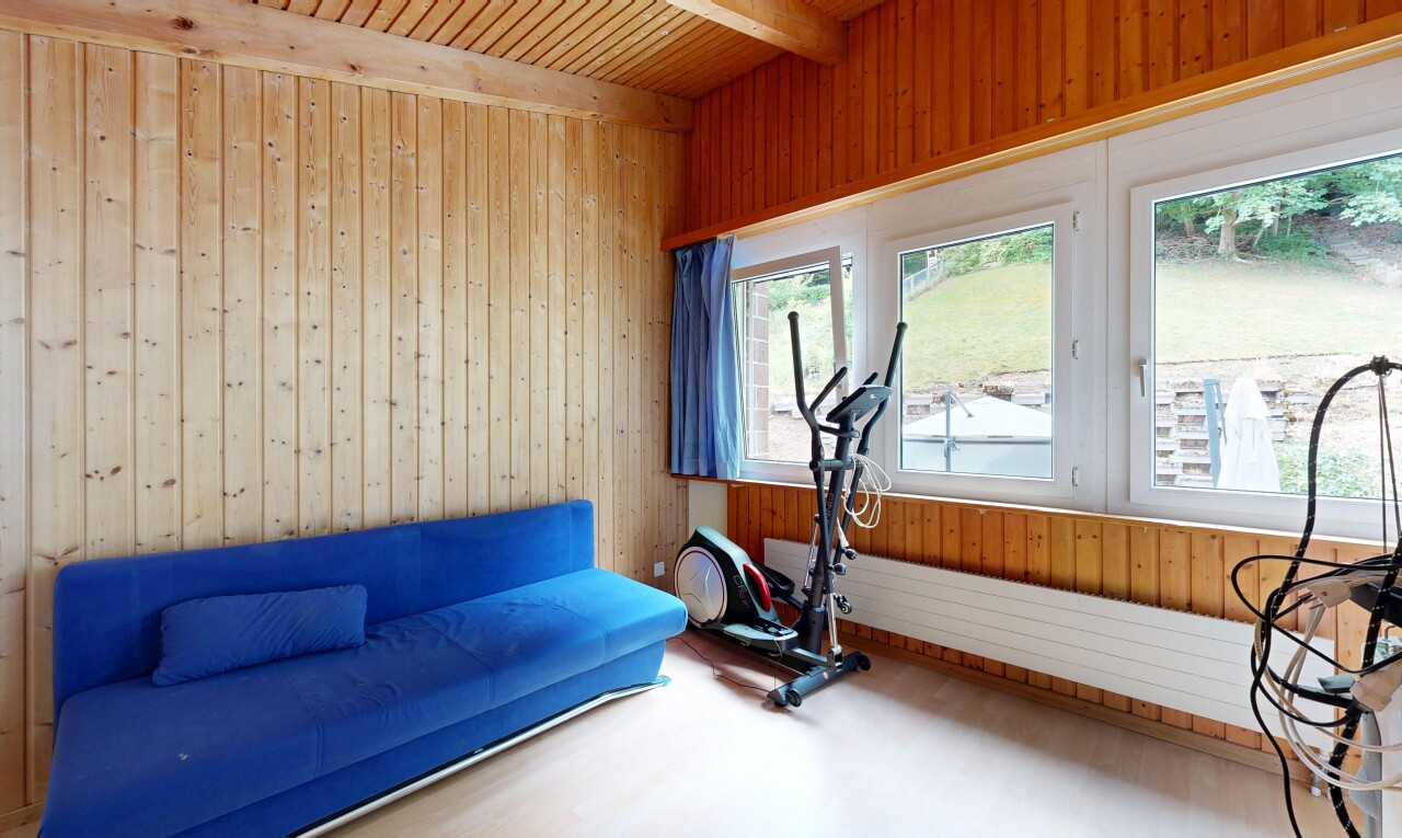 exercise room with wood walls, a wooden ceiling with exposed beams, and wood finished floors