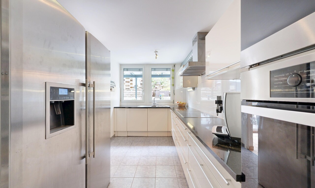 kitchen with stainless steel appliances, dark countertops, and light tile patterned flooring