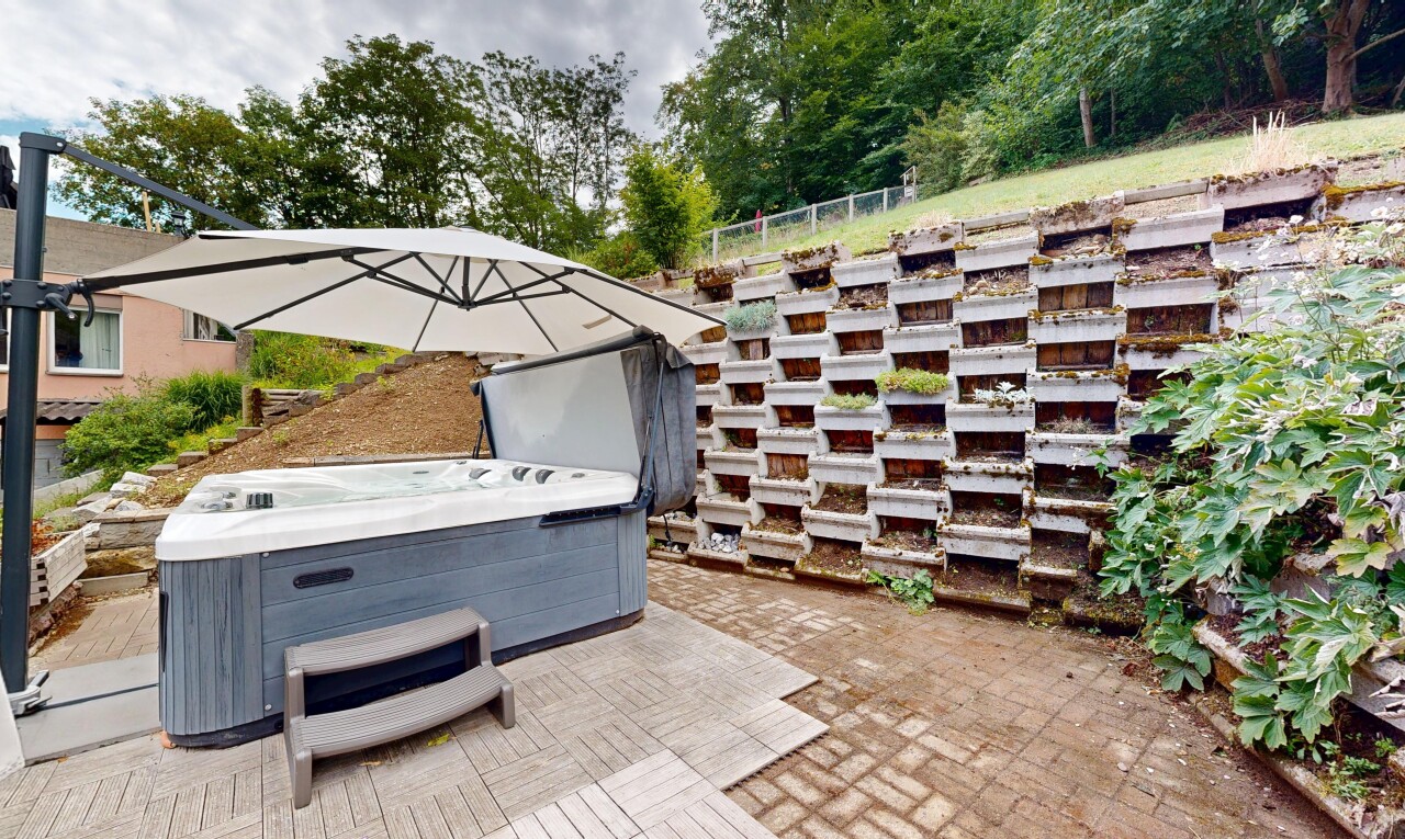 terrace with a hot tub and a patio