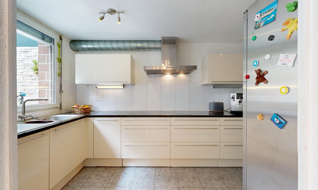 kitchen featuring fridge, dark countertops, cream cabinets, modern cabinets, and backsplash