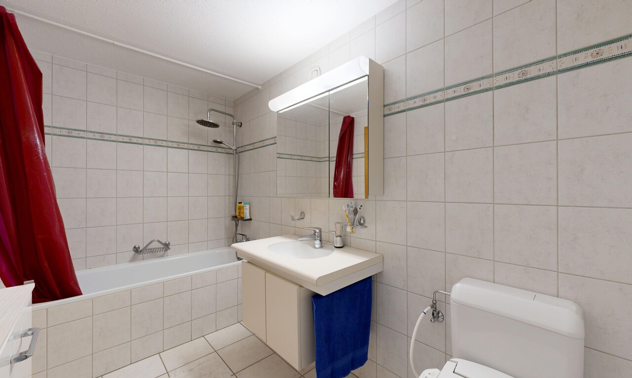full bathroom with tile walls, tiled shower / bath combo, vanity, and light tile patterned flooring