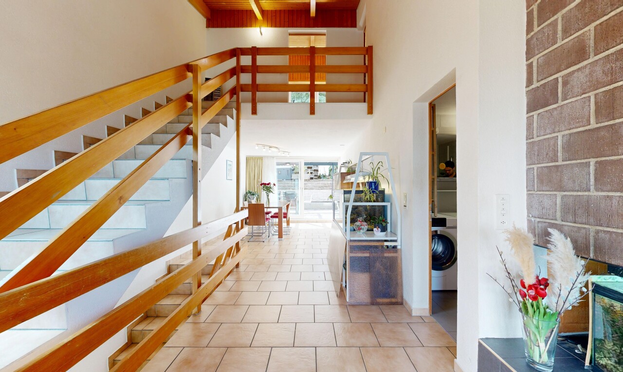 stairs featuring washer / dryer, a high ceiling, tile patterned floors, and track lighting