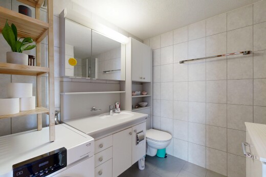 bathroom with tile walls, vanity, and dark tile patterned floors