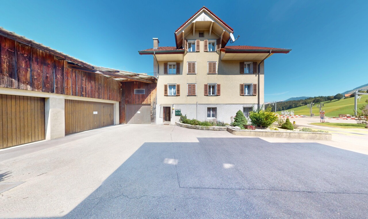 façade avec property visible, day time, bardage en stuc, garage, et allée