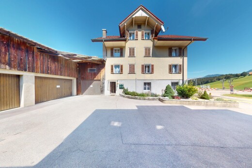façade avec property visible, day time, bardage en stuc, garage, et allée