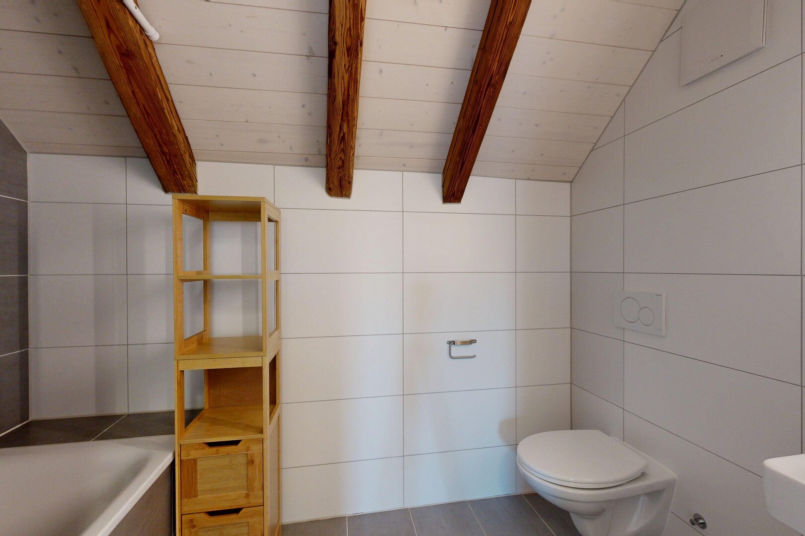 salle de bains avec plafond voûté, toilette, mur en carrelage, bain, et plafond à poutres