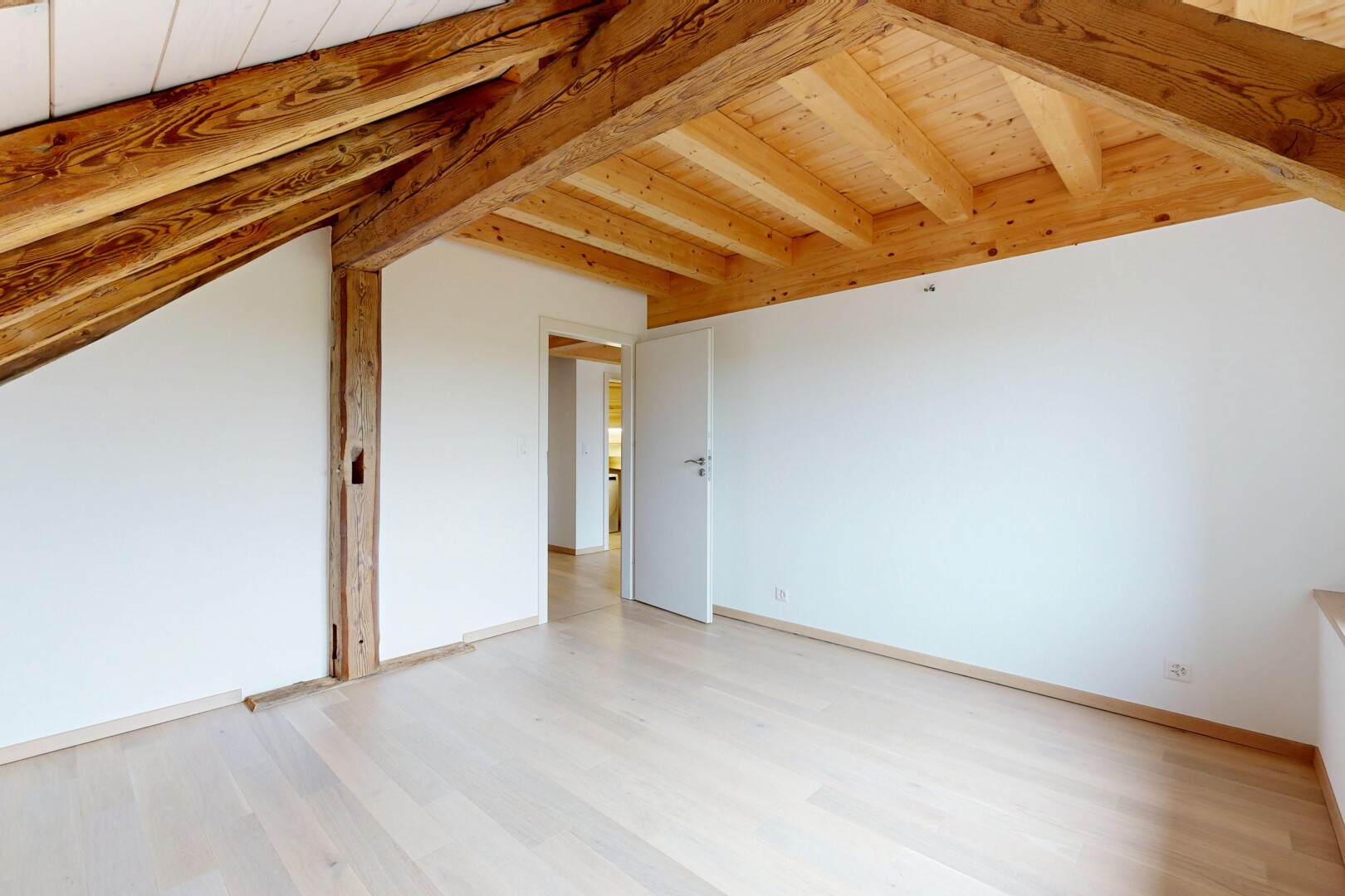 pièce vide avec sol en finition bois, plafond en bois, plafond à poutres, et cloison sèche