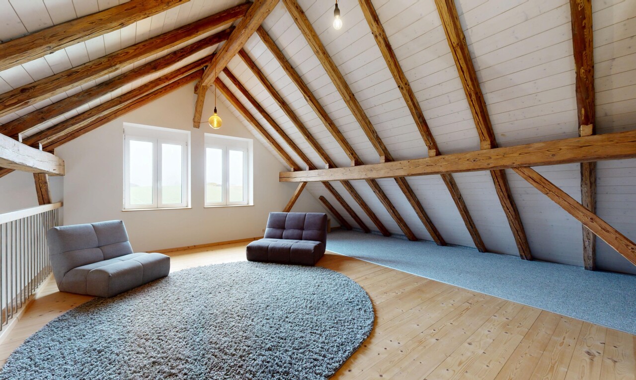 salon avec plafond cathédrale, plafond à poutres, lumière naturelle, sol en finition bois, et plafond voûté