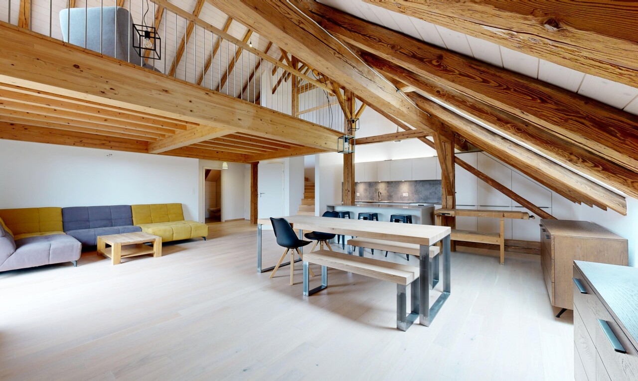 espace intérieur avec plafond à poutres, sol en finition bois, plafond voûté, et cloison sèche