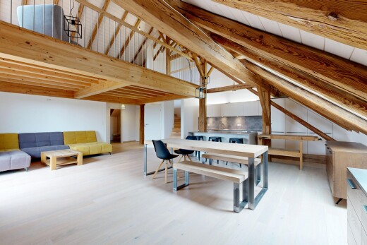 espace intérieur avec plafond à poutres, sol en finition bois, plafond voûté, et cloison sèche