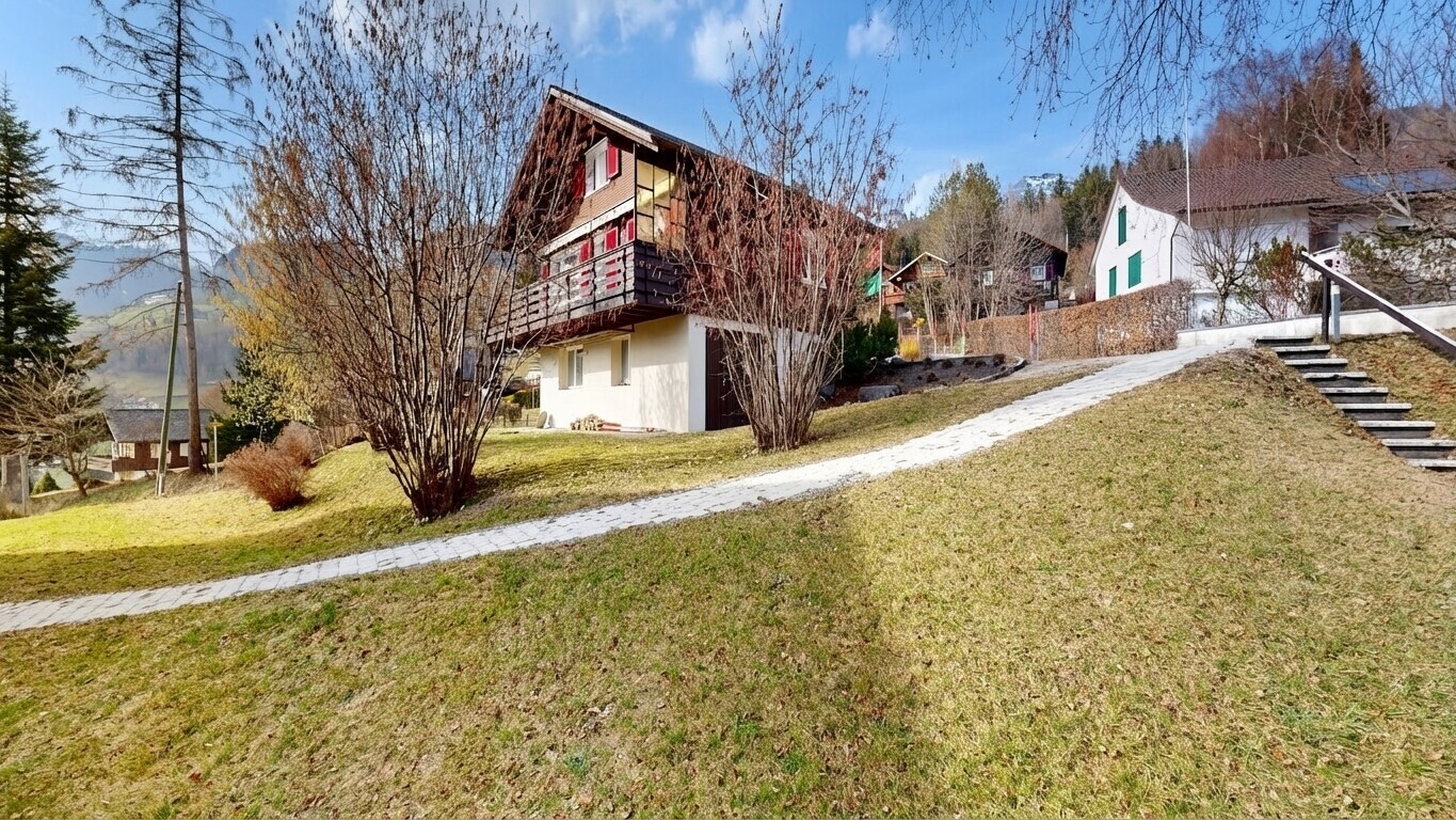 outdoor house with a lawn and a balcony
