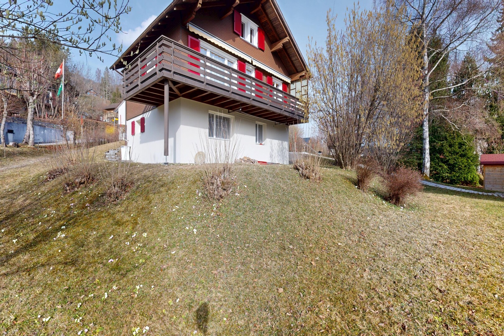 outdoor house featuring a balcony, stucco siding, and a yard