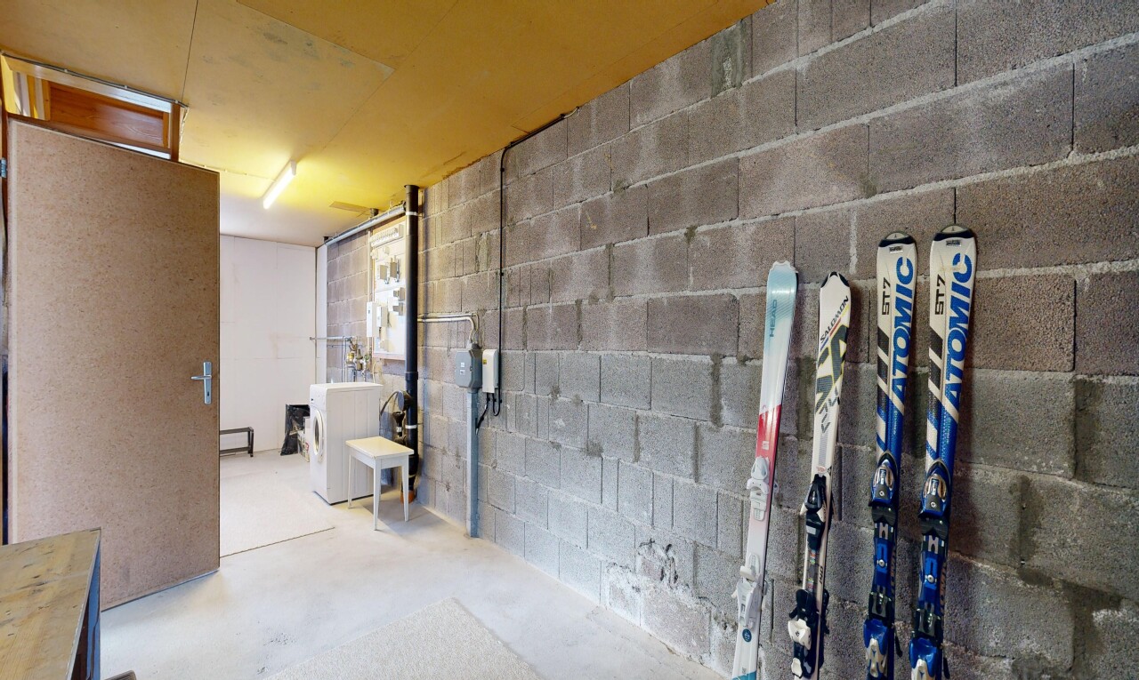interior space with concrete block wall, unfinished concrete floors, and washer / dryer
